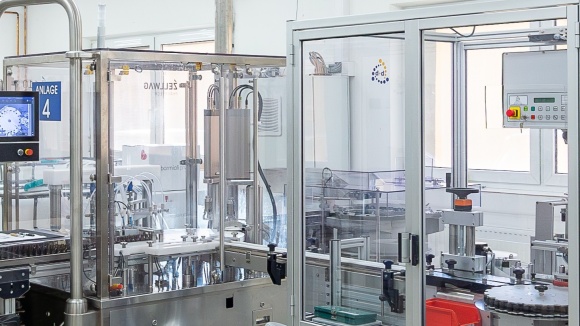Eine moderne, automatisierte Industriefertigungsanlage mit Glasabdeckung und Bedienpanel