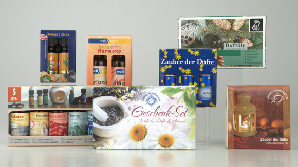 Drei Verpackungseinheiten mit jeweils 5 Flaschen in bunten Verpackungen mit dem Aufdruck Zauber der D&uuml;fte und Wellness mit 100 % &auml;therischen &Ouml;len